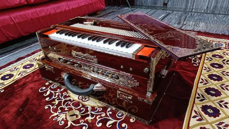 side view of brown walnut 3 line 9 scale changer harmonium with black-white keys
